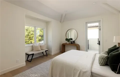 a bedroom with a bed a mirror and lamp