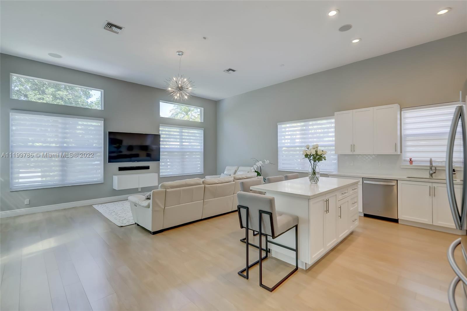 9901 North Abiaca Circle Davie, FL 33328 - Photo 13 of 46 a living room with furniture a flat screen tv and kitchen view