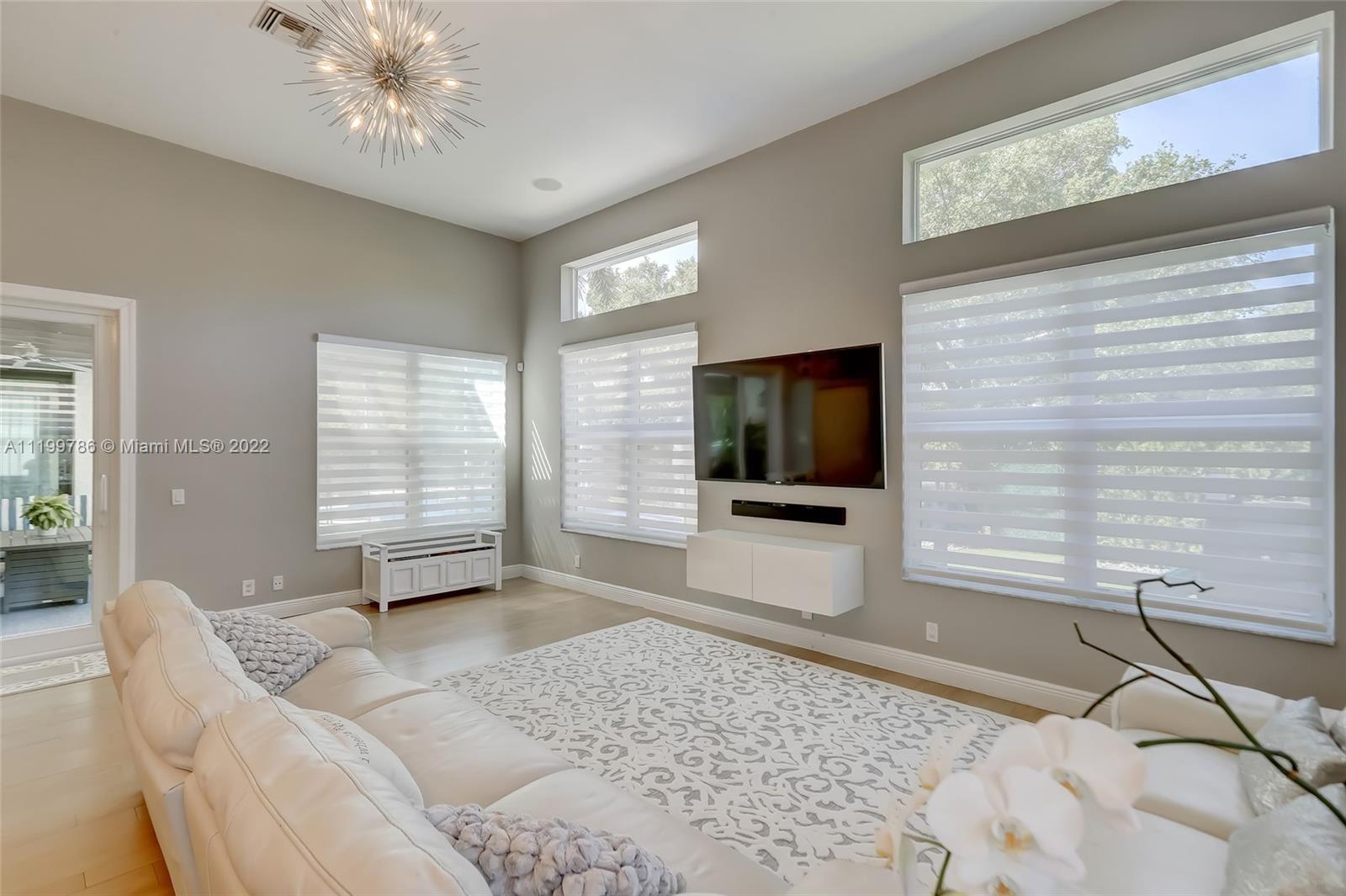 9901 North Abiaca Circle Davie, FL 33328 - Photo 15 of 46 a living room with a couch and a flat screen tv