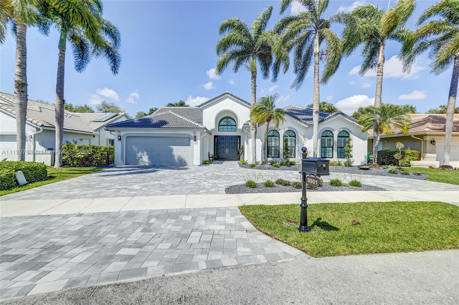 9901 North Abiaca Circle Davie, FL 33328 - Photo 2 of 46 a front view of multiple houses with yard