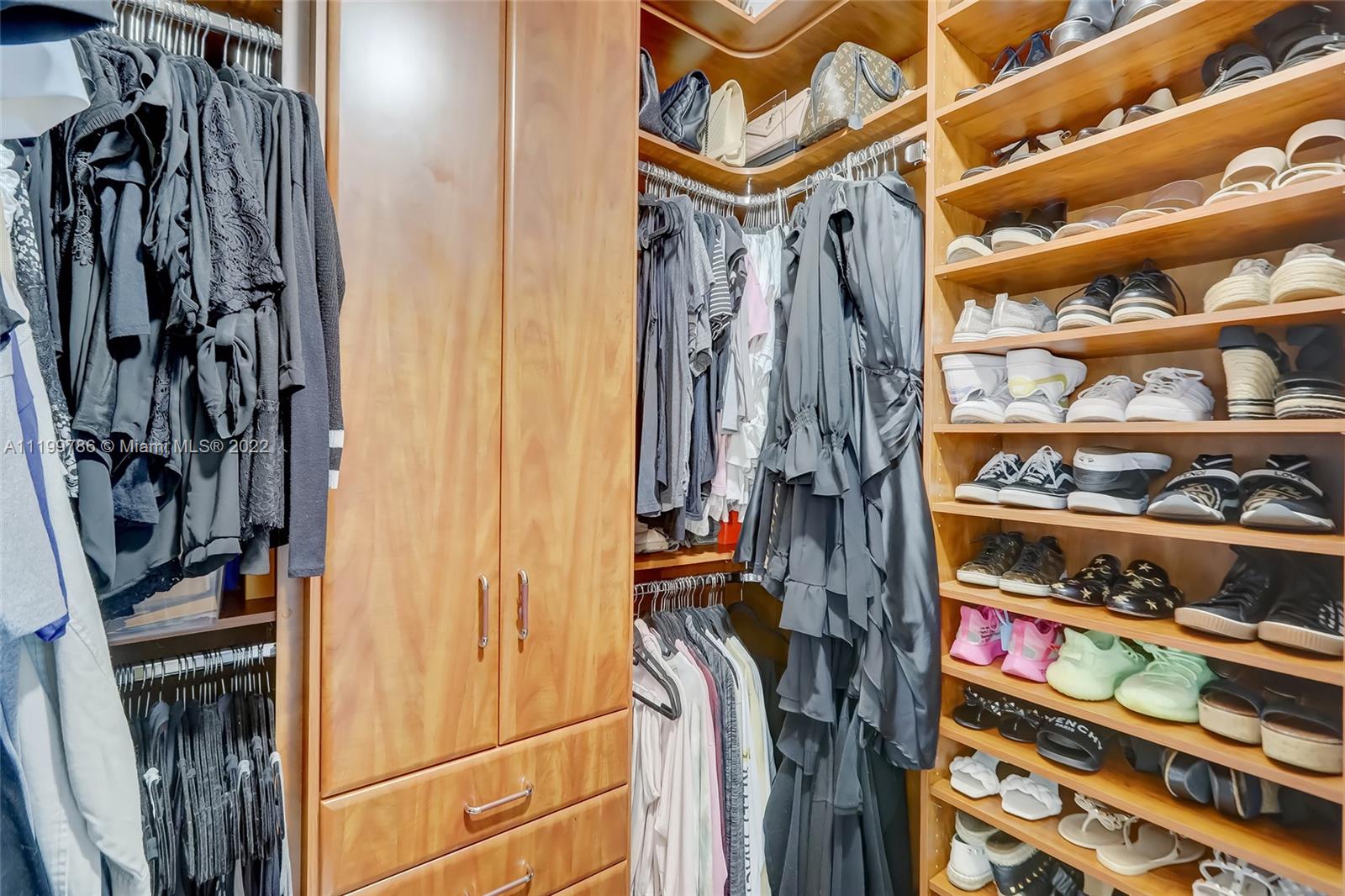 9901 North Abiaca Circle Davie, FL 33328 - Photo 34 of 46 a view of walk in closet with clothes and shoes