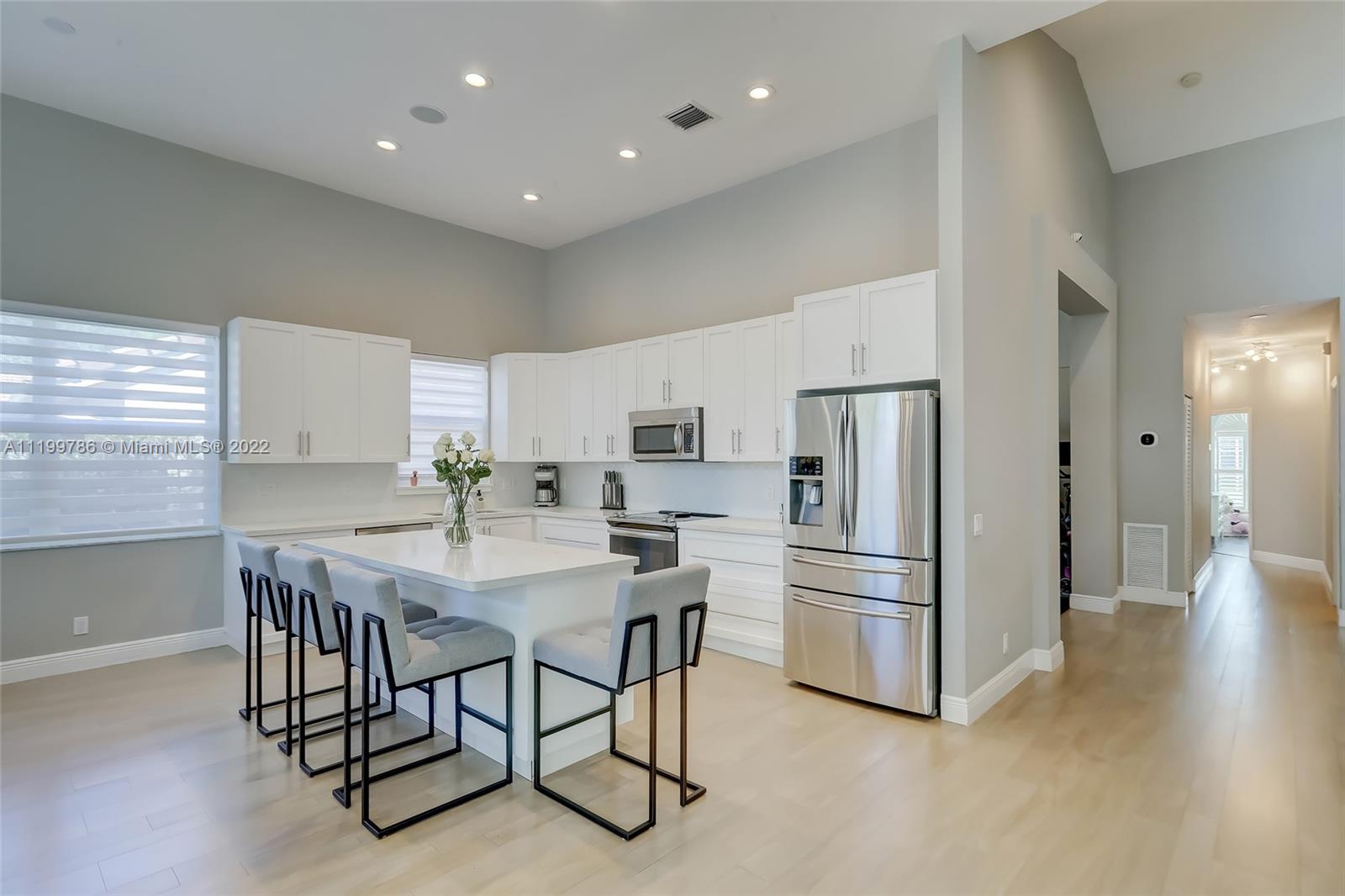 9901 North Abiaca Circle Davie, FL 33328 - Photo 10 of 46 a kitchen with stainless steel appliances a refrigerator a stove a dining table and chairs