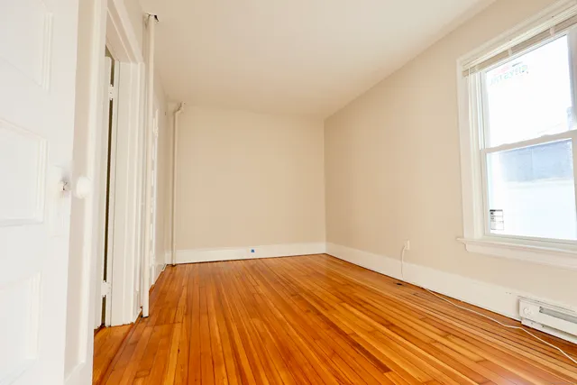 a view of a room with wooden floor and a window