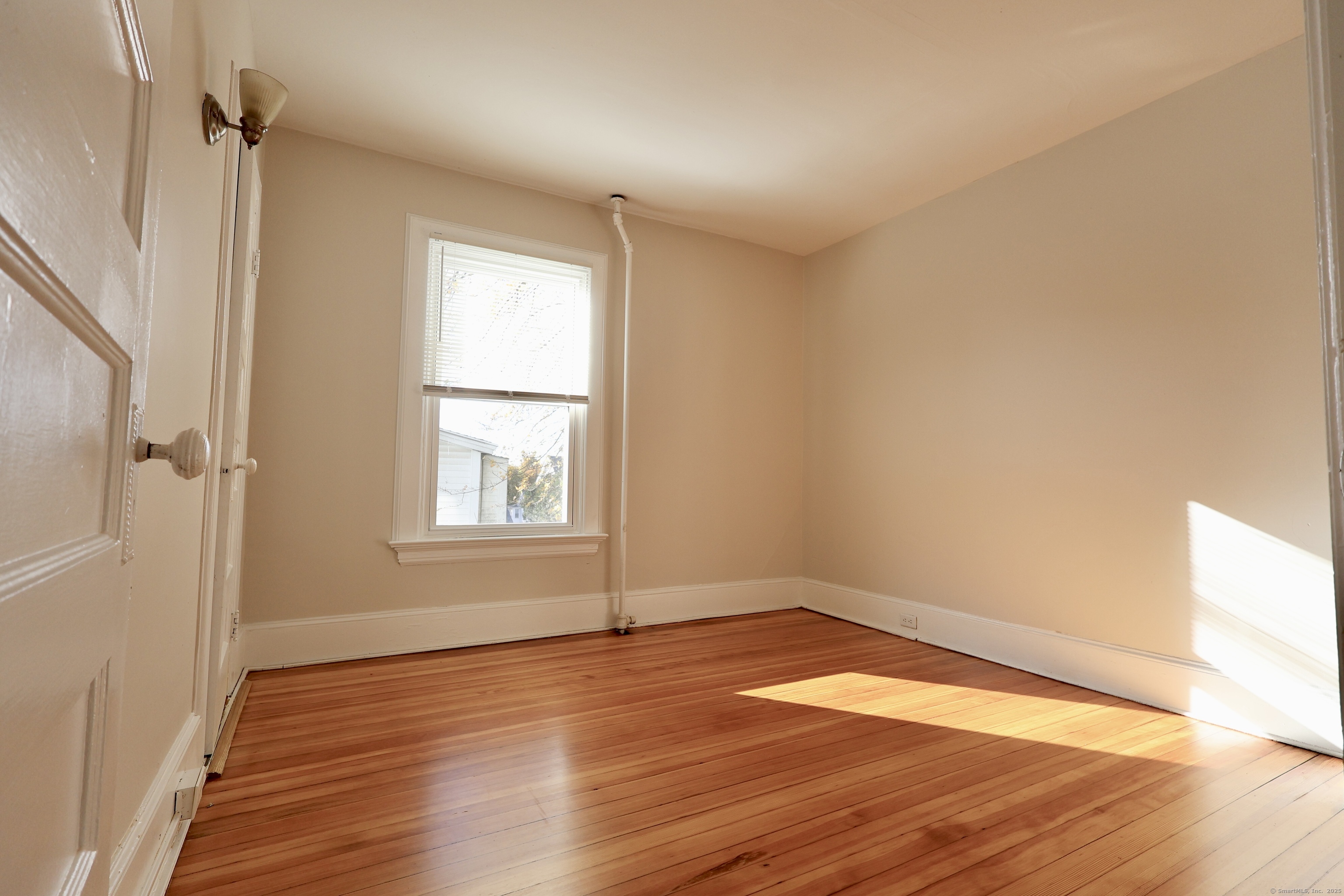 101 Stearns Street Bristol, CT 06010 - Photo 14 of 18 an empty room with wooden floor and windows
