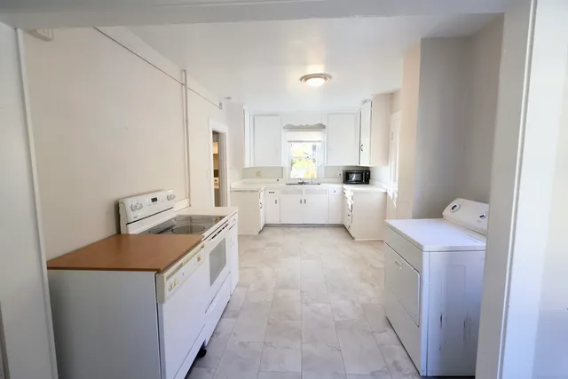 a utility room with cabinets washer and dryer