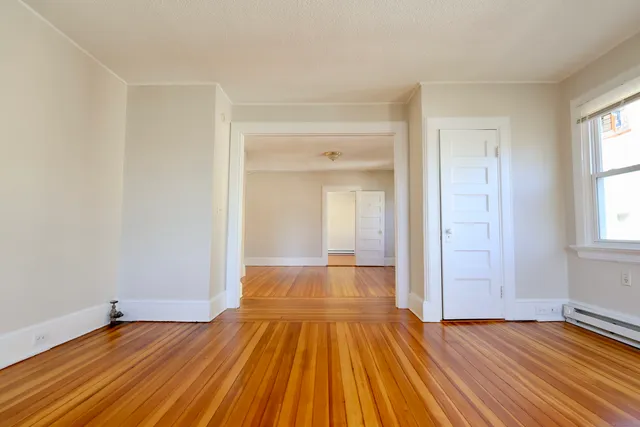 wooden floor in an empty room with a window