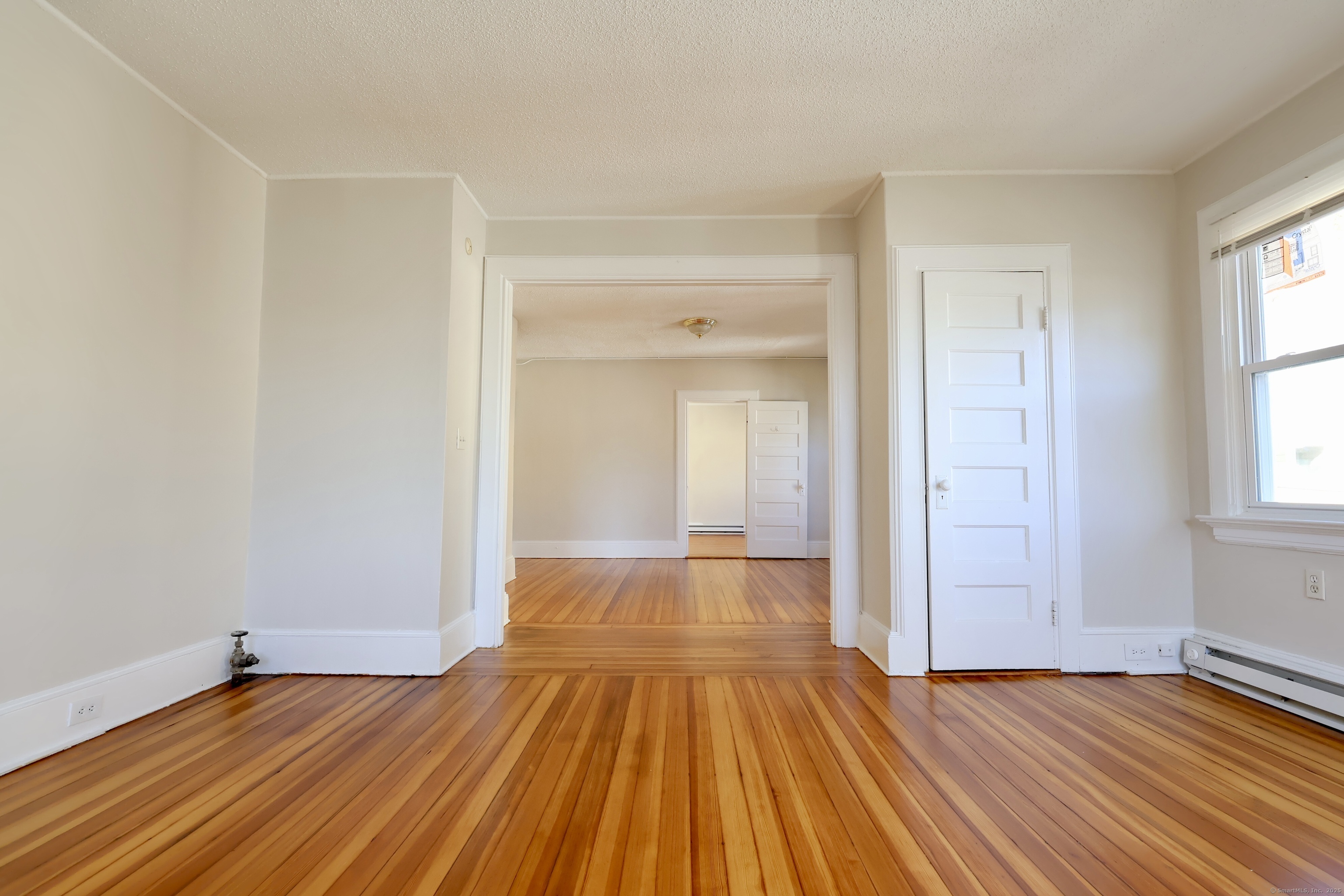 101 Stearns Street Bristol, CT 06010 - Photo 6 of 18 wooden floor in an empty room with a window
