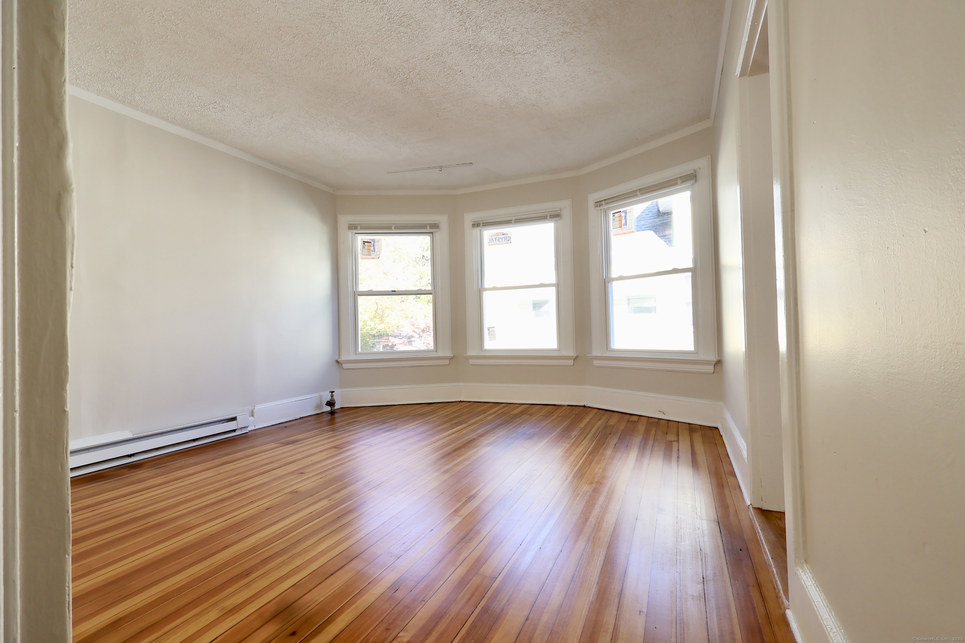 101 Stearns Street Bristol, CT 06010 - Photo 10 of 18 an empty room with wooden floor and windows