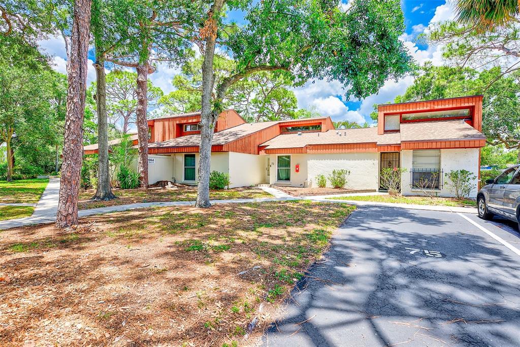 2064 Sunset Point Road, Unit 73 Clearwater, FL 33765 - Photo 4 of 58 a front view of a house with a yard table and chairs