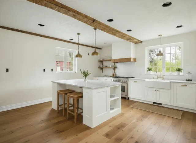 a kitchen with white cabinets stainless steel appliances and wooden floor