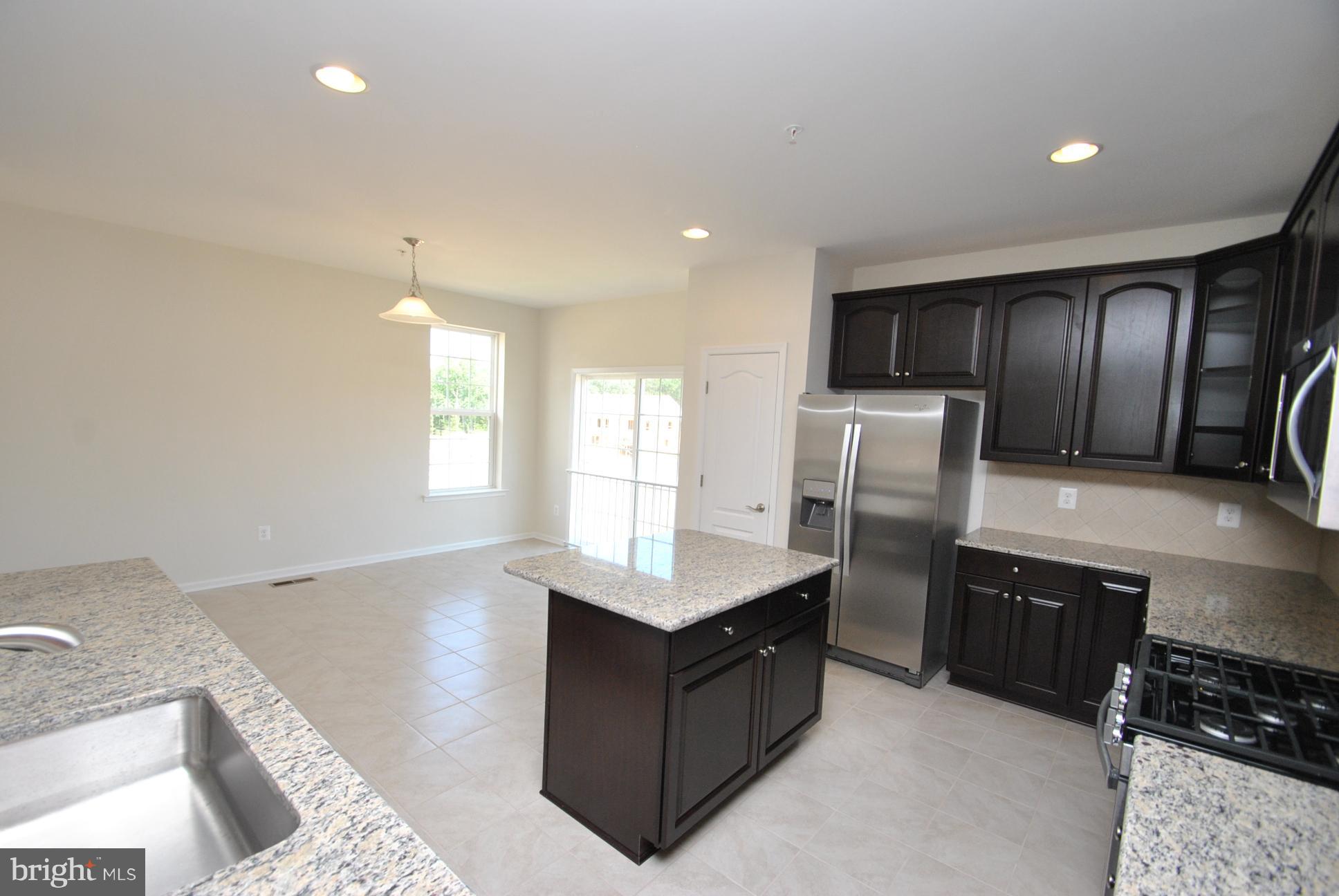 944 Winter Run Road Baltimore, MD 21220 - Photo 12 of 30 a kitchen with stainless steel appliances kitchen island granite countertop a refrigerator and a sink