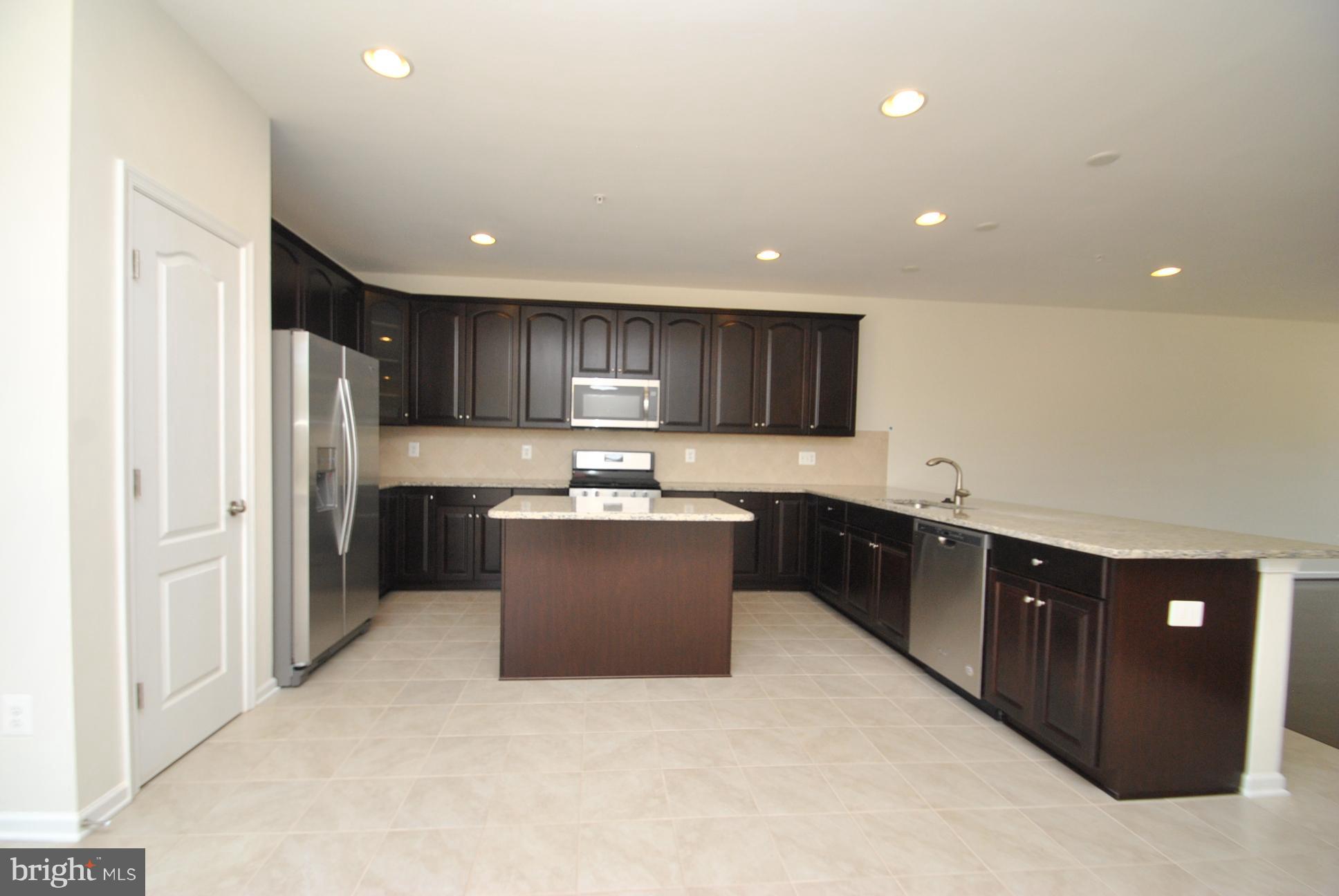 944 Winter Run Road Baltimore, MD 21220 - Photo 14 of 30 a kitchen with stainless steel appliances granite countertop a refrigerator and a wooden cabinets