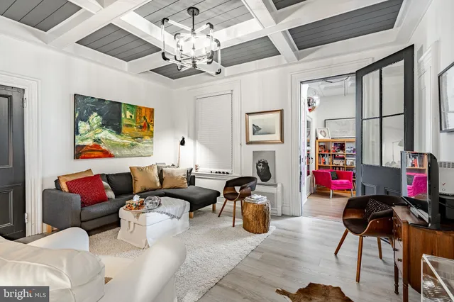 a living room with furniture a chandelier and a flat screen tv