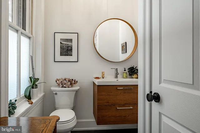 a bathroom with a toilet a sink and mirror