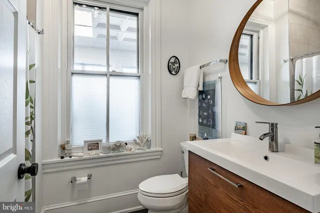 a bathroom with a toilet a sink and a mirror