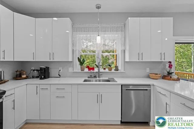 a kitchen with stainless steel appliances a sink a stove and cabinets