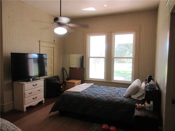 a bedroom with a bed and a flat tv screen on dresser