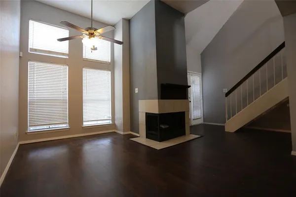 a view of wooden floor fire place and windows in an empty room