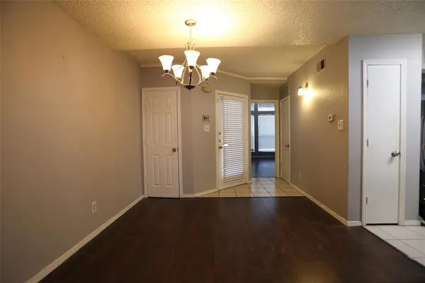 an empty room with wooden floor and ceiling fan