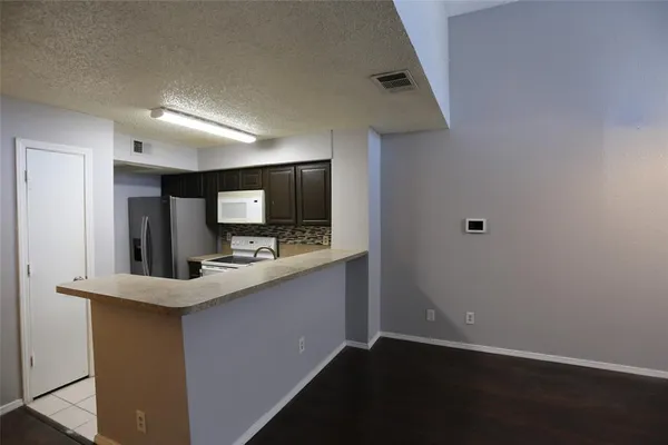 a kitchen with stainless steel appliances granite countertop a sink and a refrigerator