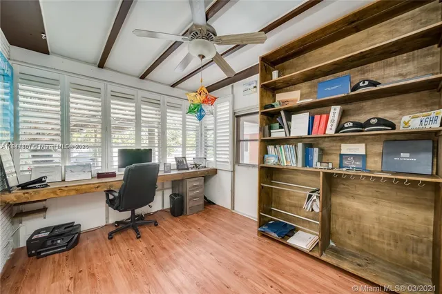 a view of a workspace with furniture and a window
