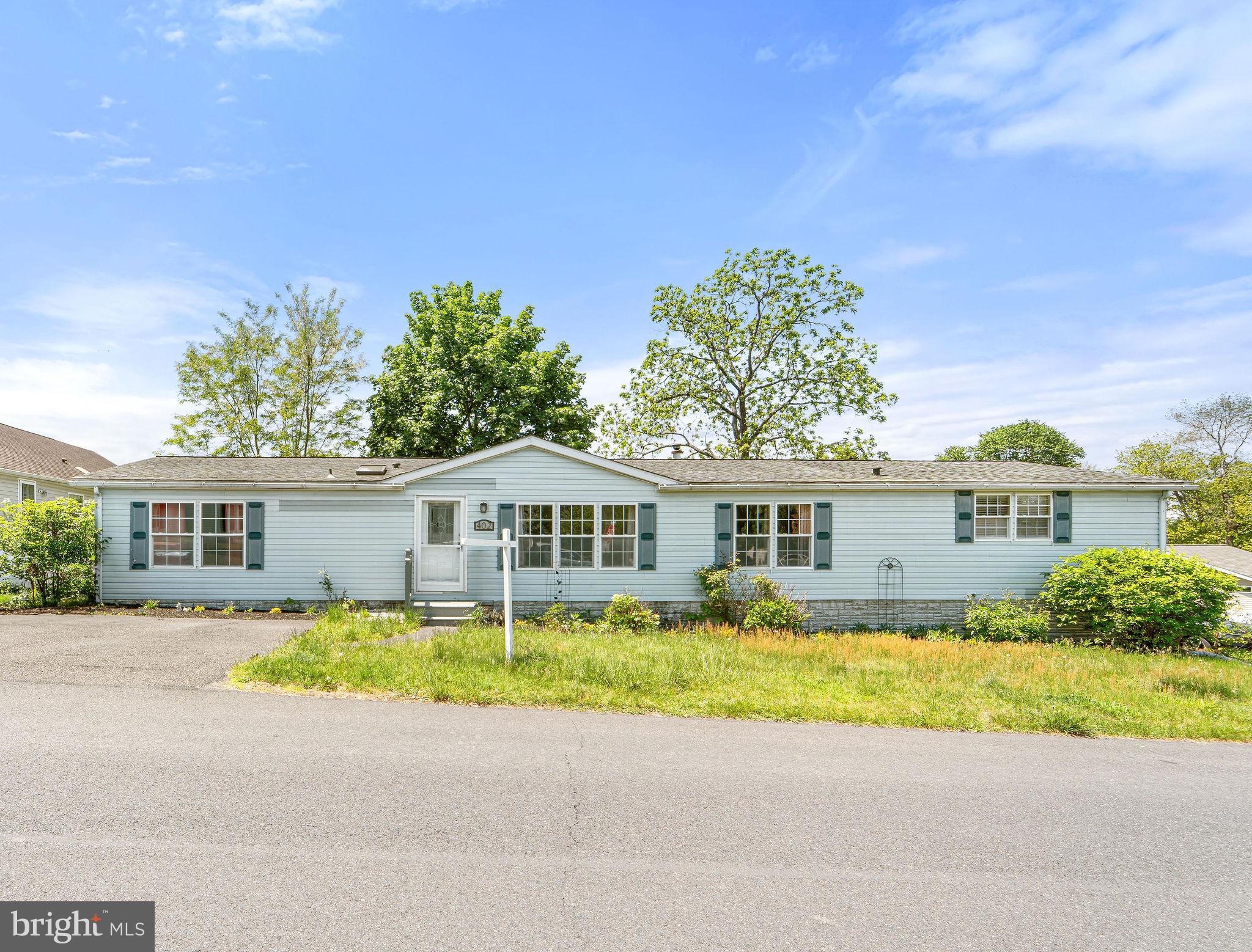 a front view of a house with a yard and potted plants