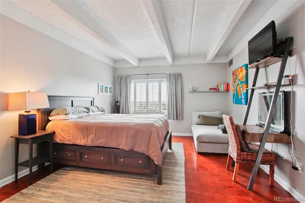 a bed sitting in a bedroom next to a window