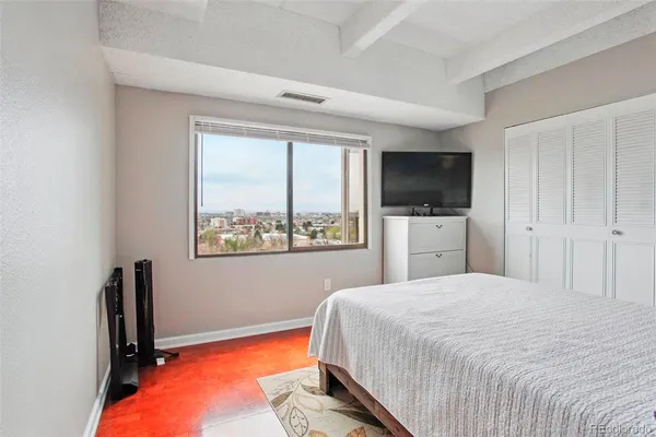 a bedroom with a bed and a painting on the wall