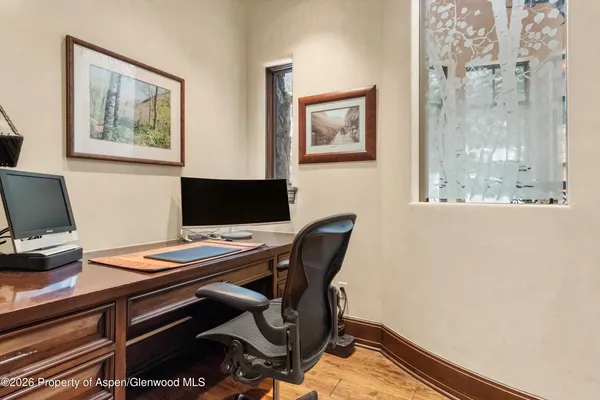 a view of a workspace with furniture and a window