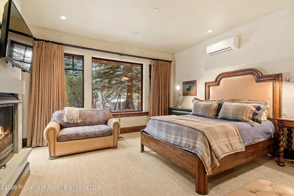 a bedroom with a large bed and a flat tv screen on dresser