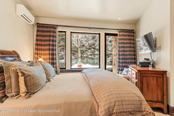 a bedroom with a bed couch and a large window