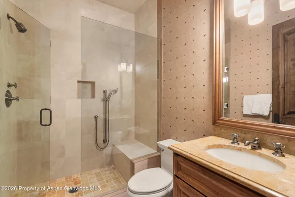 a bathroom with a double vanity sink a toilet a mirror and shower