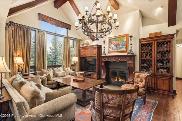 a living room with furniture a fireplace and a chandelier