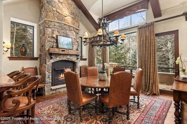 a dining room with furniture a fireplace a rug and wooden floor
