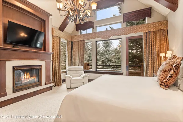 a large bedroom with a bed and a flat screen tv