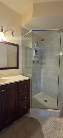 a bathroom with a shower a mirror and a sink