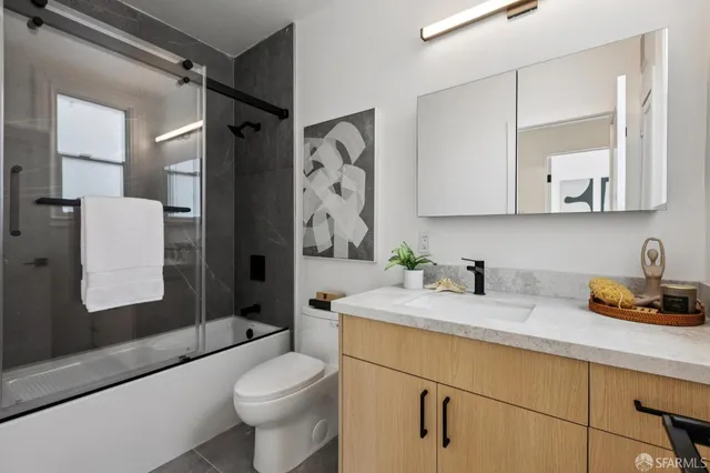 a bathroom with a granite countertop sink toilet and shower