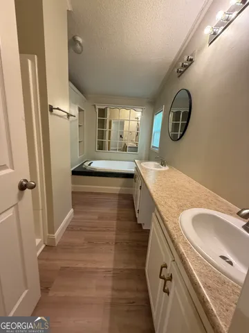 a bathroom with a granite countertop double vanity sink and mirror