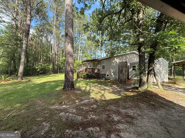 a view of a house with backyard and a tree