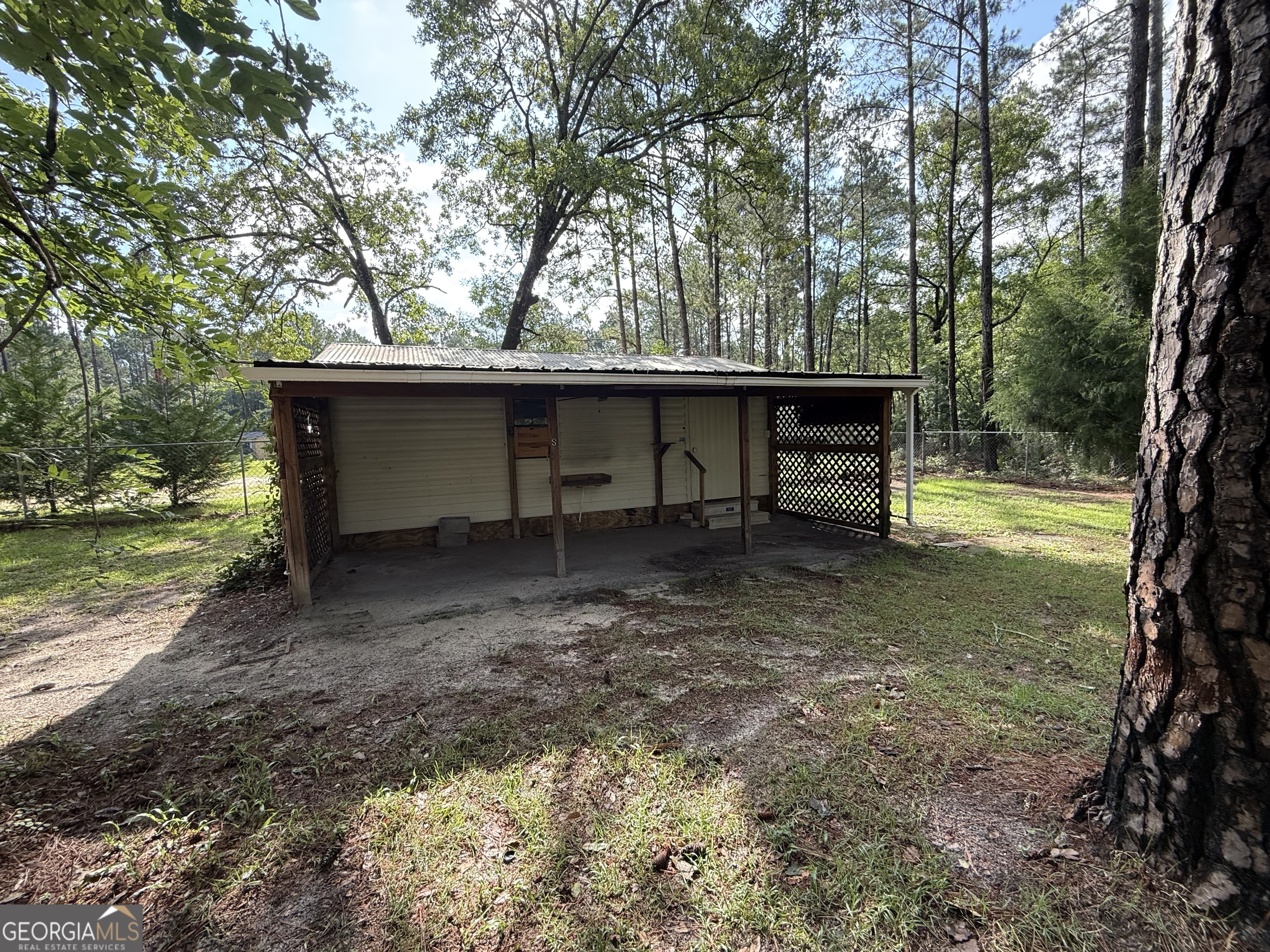 179 Creek Ridge Road Claxton, GA 30417 - Photo 4 of 19 a view of a wooden house with a yard and large trees