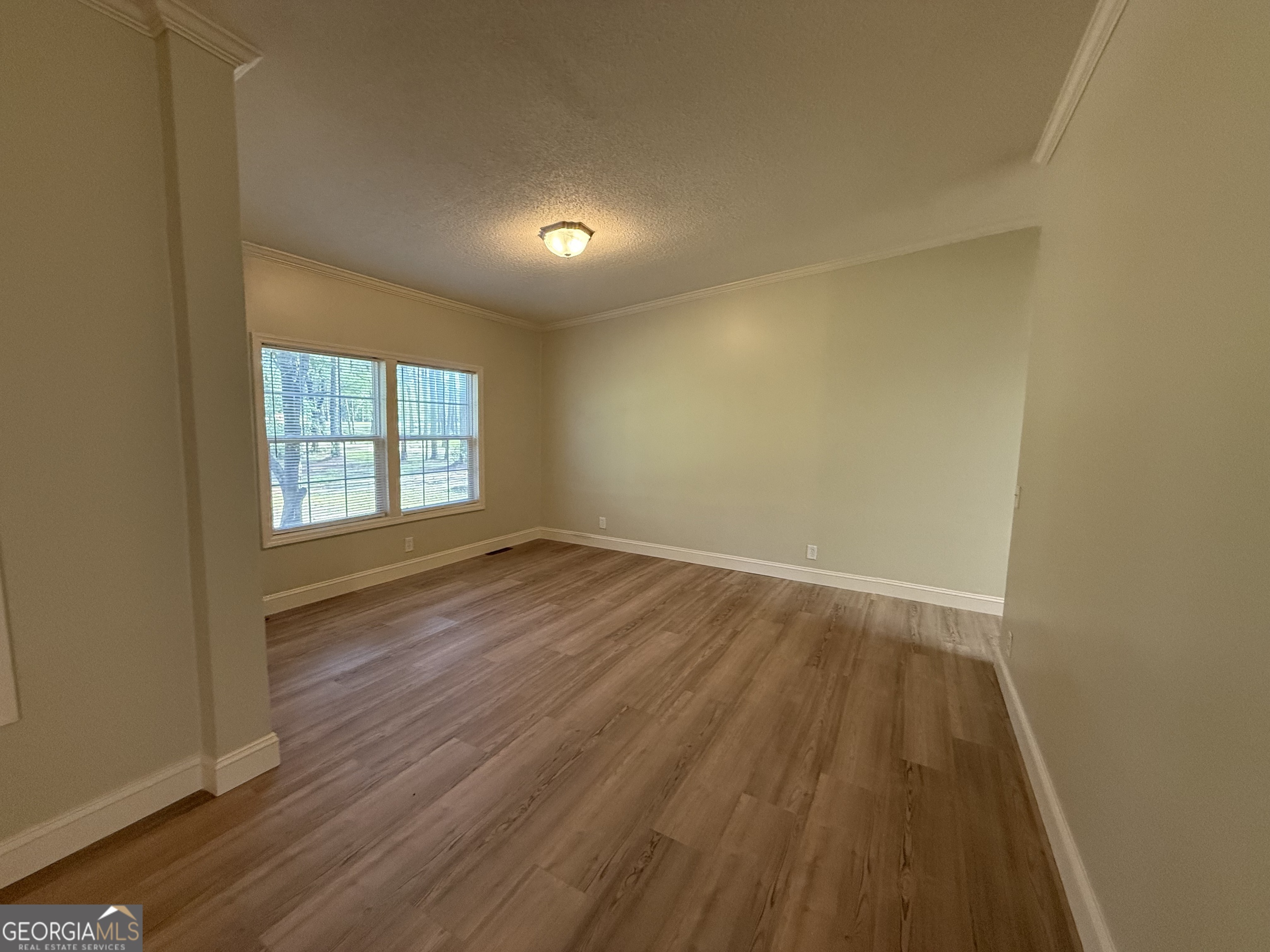 179 Creek Ridge Road Claxton, GA 30417 - Photo 6 of 19 an empty room with wooden floor and windows