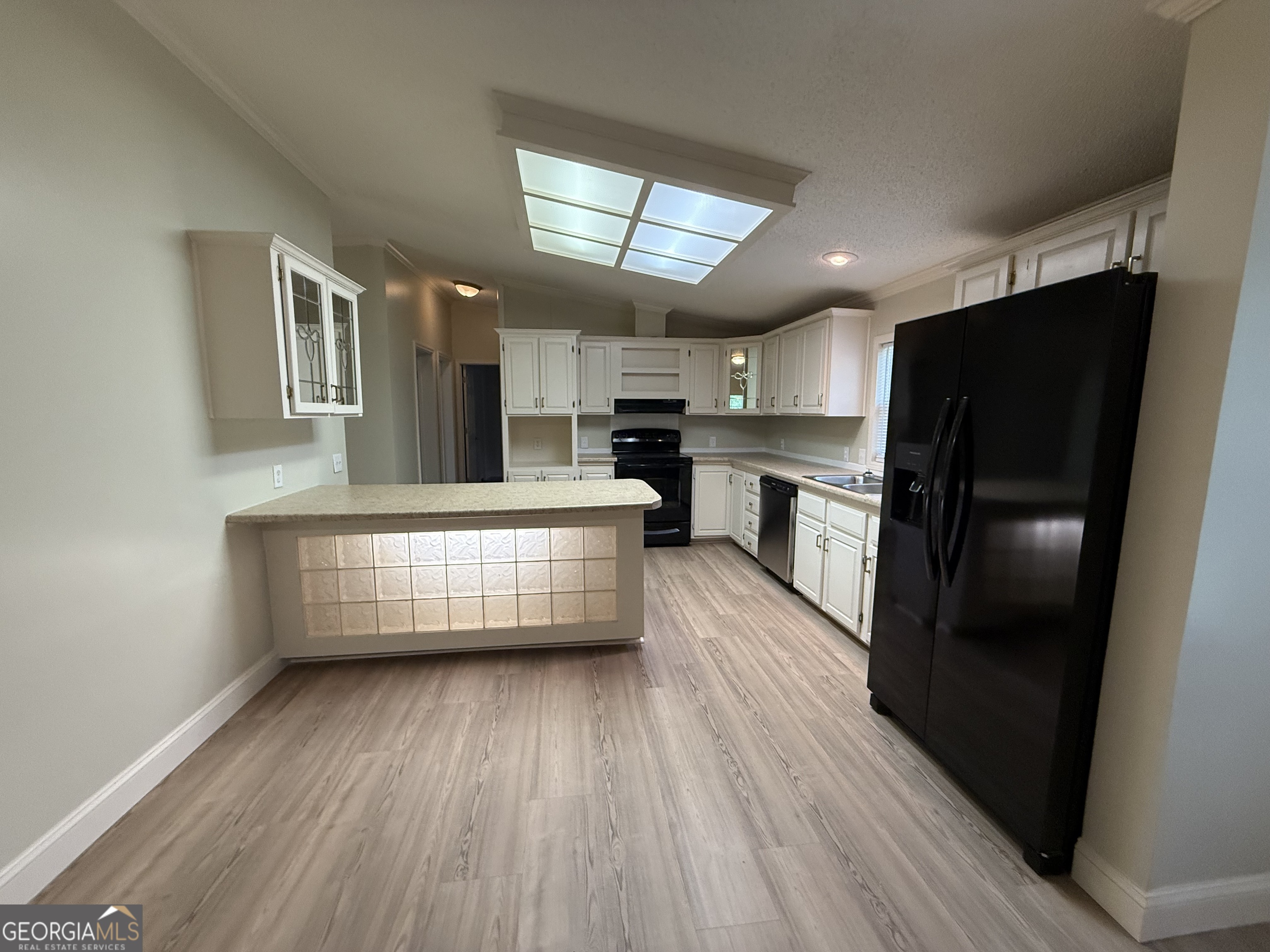 179 Creek Ridge Road Claxton, GA 30417 - Photo 7 of 19 a kitchen with granite countertop a refrigerator a stove and white cabinets with wooden floor