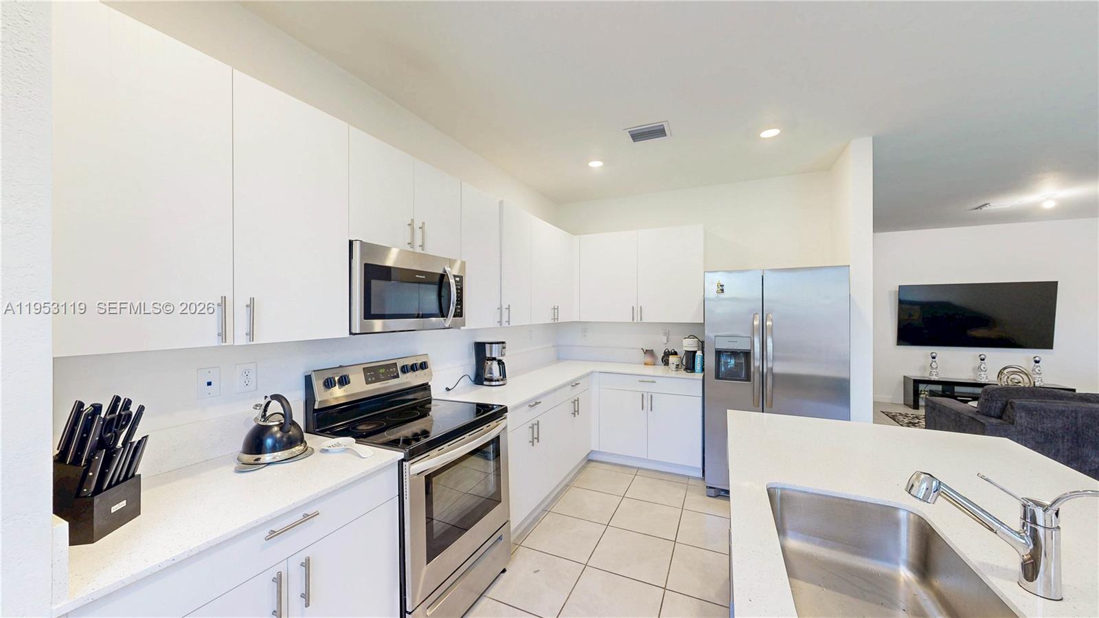 16233 Southwest 290th Terrace Homestead, FL 33033 - Photo 12 of 43 a kitchen with stainless steel appliances a stove a sink a microwave a refrigerator and cabinets