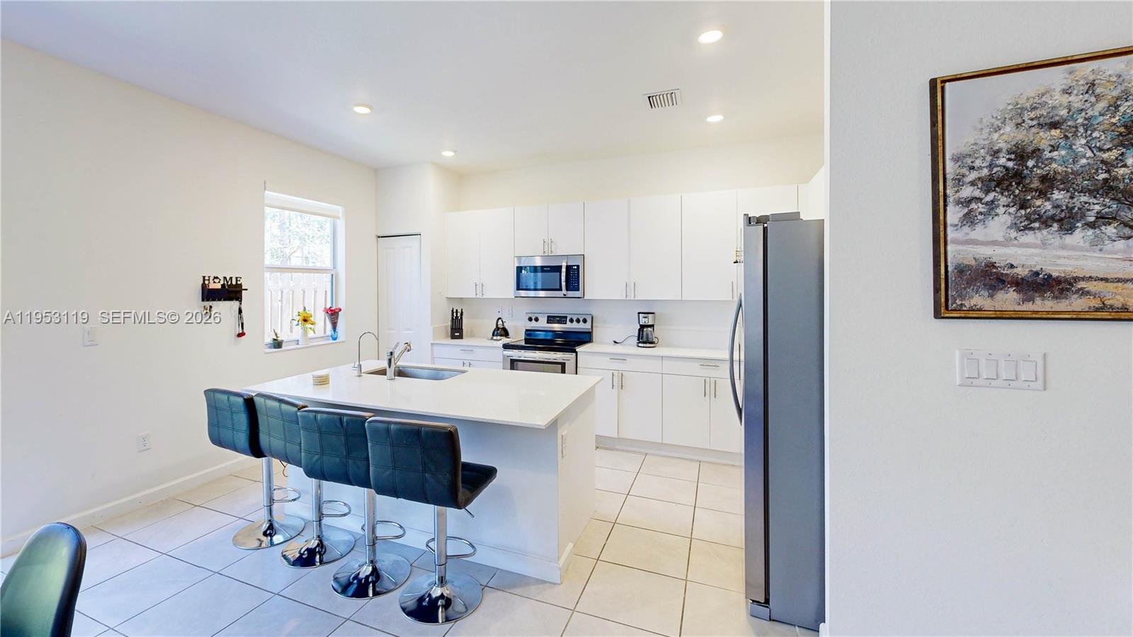16233 Southwest 290th Terrace Homestead, FL 33033 - Photo 10 of 43 a kitchen with stainless steel appliances kitchen island granite countertop a refrigerator and a stove top oven