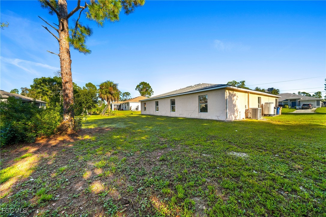 4733-4735 30th Street Southwest Lehigh Acres, FL 33973 - Photo 34 of 43 a front view of a house with garden