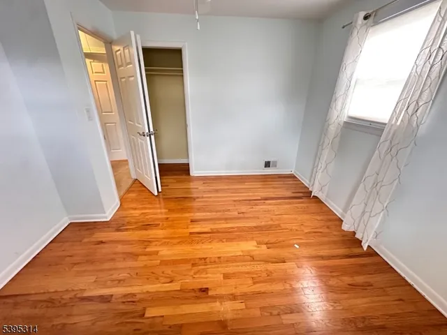 a view of a room with wooden floor and a window