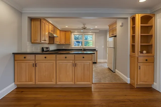 a kitchen with granite countertop a refrigerator and cabinets