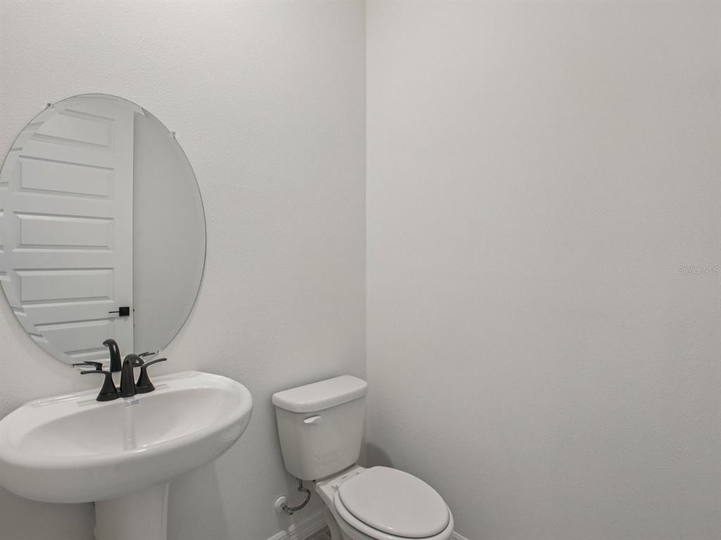 10821 Heirloom Farms Run Parrish, FL 34221 - Photo 5 of 13 a bathroom with a sink a toilet and mirror