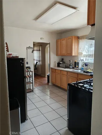 a kitchen with stainless steel appliances granite countertop a refrigerator a sink a stove top oven and a dining table