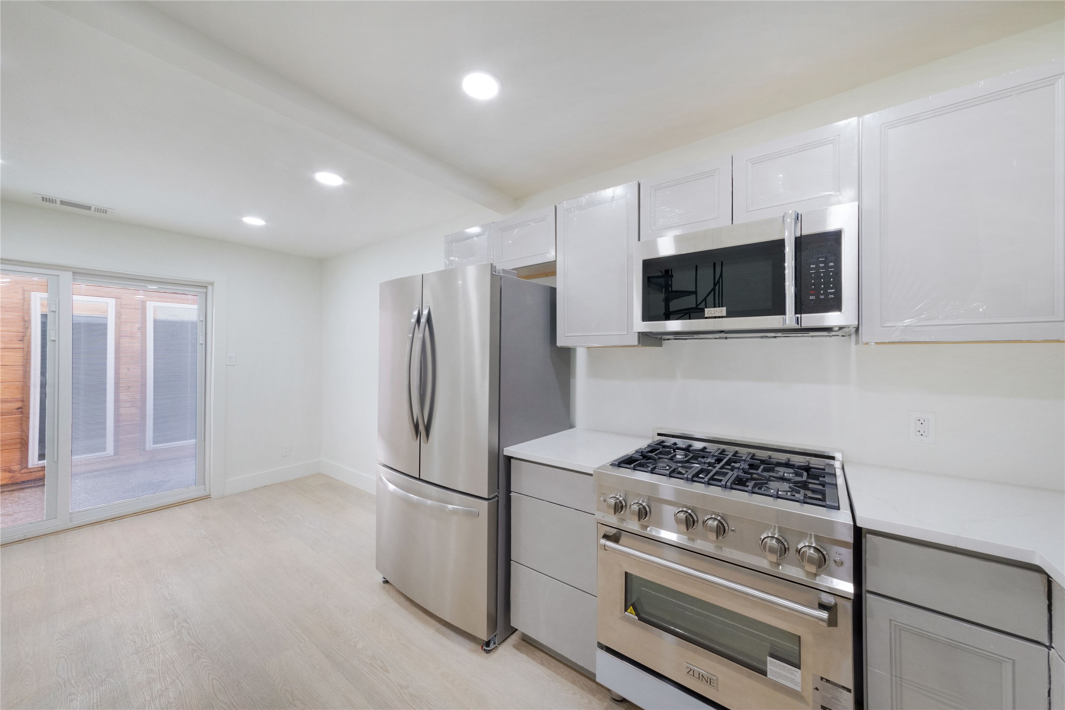 8807 Merion Circle Austin, TX 78754 - Photo 7 of 18 A well-equipped kitchen space features a full suite of stainless steel appliances and smooth countertops, all illuminated by recessed lighting.